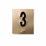Shows a jamb braille plate with black character satin bronze background